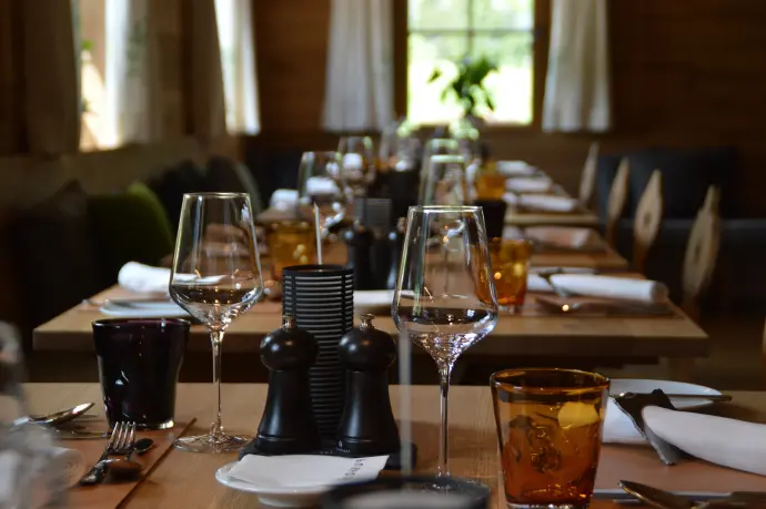 a long table with wine glasses and silverware on it