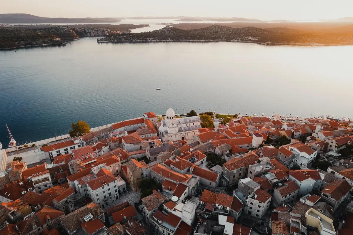 Povijesni grad u Hrvatskoj, Šibenik se nalazi na Jadranskom moru. Grad je poznat po svojim crvenim krovovima i povijesnoj katedrali. Ova slika dočarava ljepotu grada iz ptičje perspektive.