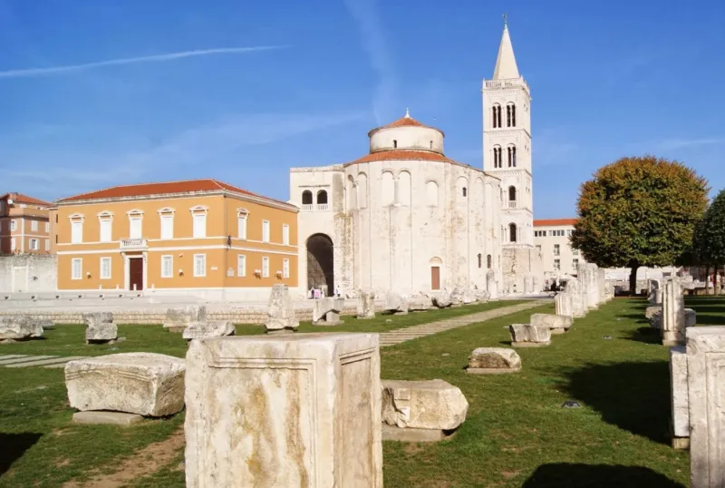 Crkva sv. Donata u Zadru, Hrvatska, s Rimskim forumom u prvom planu. Crkva je izgrađena od kamena i ima visok toranj u sredini